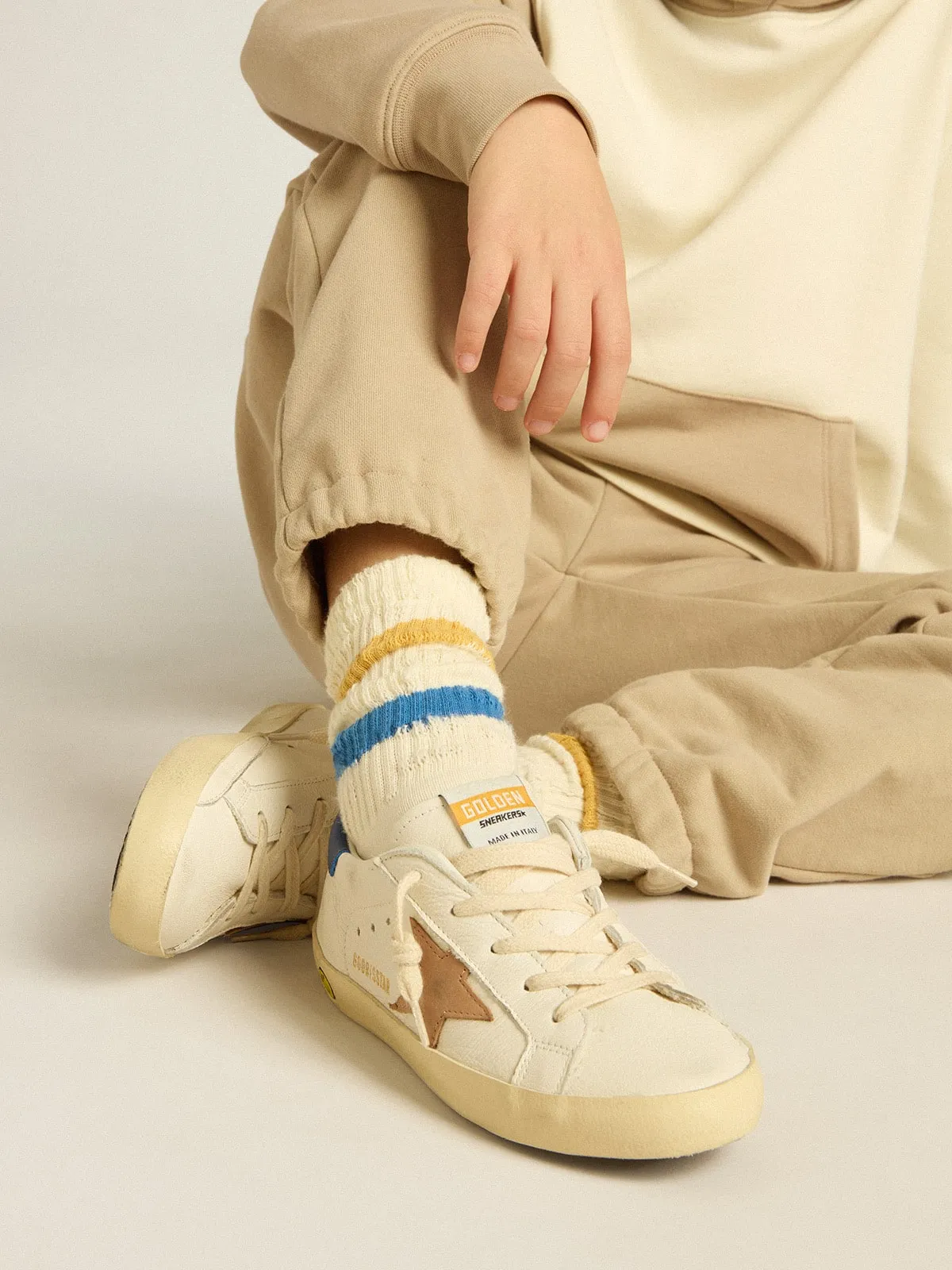 Worn white Kids socks with distressed details and two-tone bright blue and mustard stripes